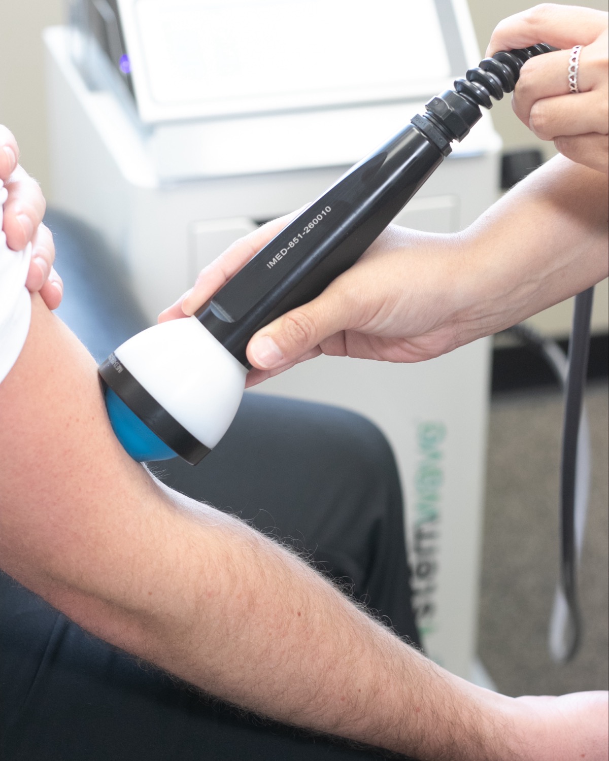StemWave acoustic wave applicator being used on a patient's elbow at Peak Performance